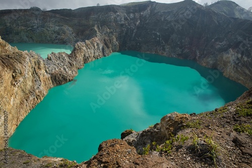 Panoramic view over the volcano Mount Kelimutu in Ende on Flores with its two sunlit turquoise crater lakes.