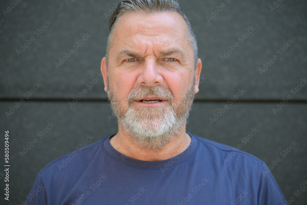 Obraz premium Bearded middle aged man staring at camera in consternation