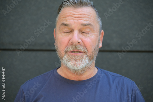 Middle aged bearded man posing with closed eyes