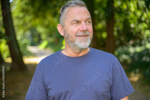 Smiling middle aged man enjoying a stroll on a hot summer day