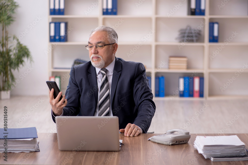 Old male employee working in the office Old male employee working in the office