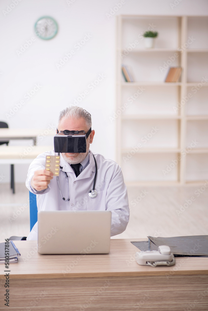 Old male doctor wearing virtual glasses in the clinic Old male doctor wearing virtual glasses in the clinic