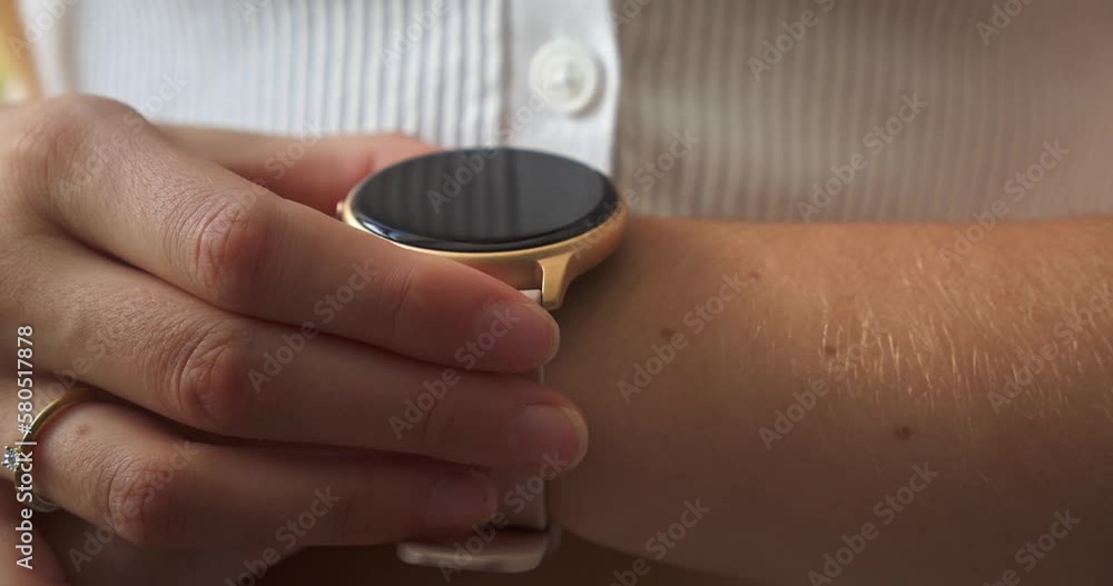 A Round Smartwatch Touching By A Female Hand While On Her Wrist. Closeup A Round Smartwatch Touching By A Female Hand While On Her Wrist. Closeup