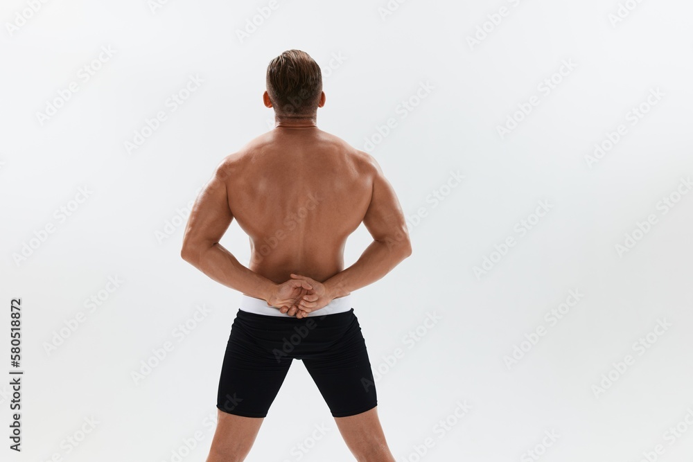Man athletic body bodybuilder in briefs with naked torso abs full-length in the background, fitness classes. Advertising, sports, active lifestyle, competition, challenge concept.