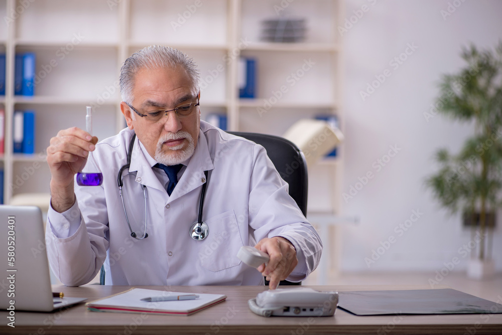 Old male doctor holding tube in the clinic Old male doctor holding tube in the clinic