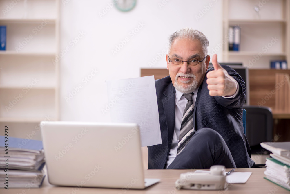 Old male boss employee working in the office Old male boss employee working in the office