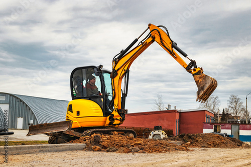 Mini excavator at the construction site. Compact construction equipment for earthworks. An indispensable assistant for earthworks. Rental of construction equipment.
