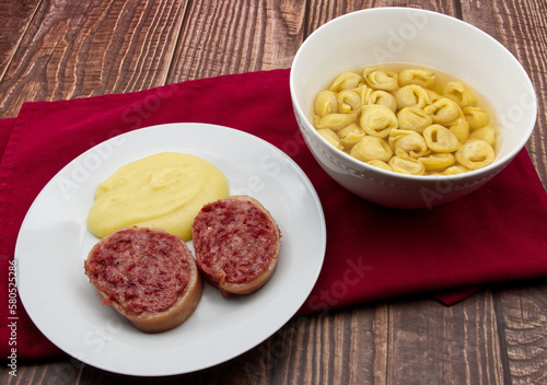 Slices of traditional Italian sausages Zampone di Modena with mashed potatoes and a Tortellini pasta dish.