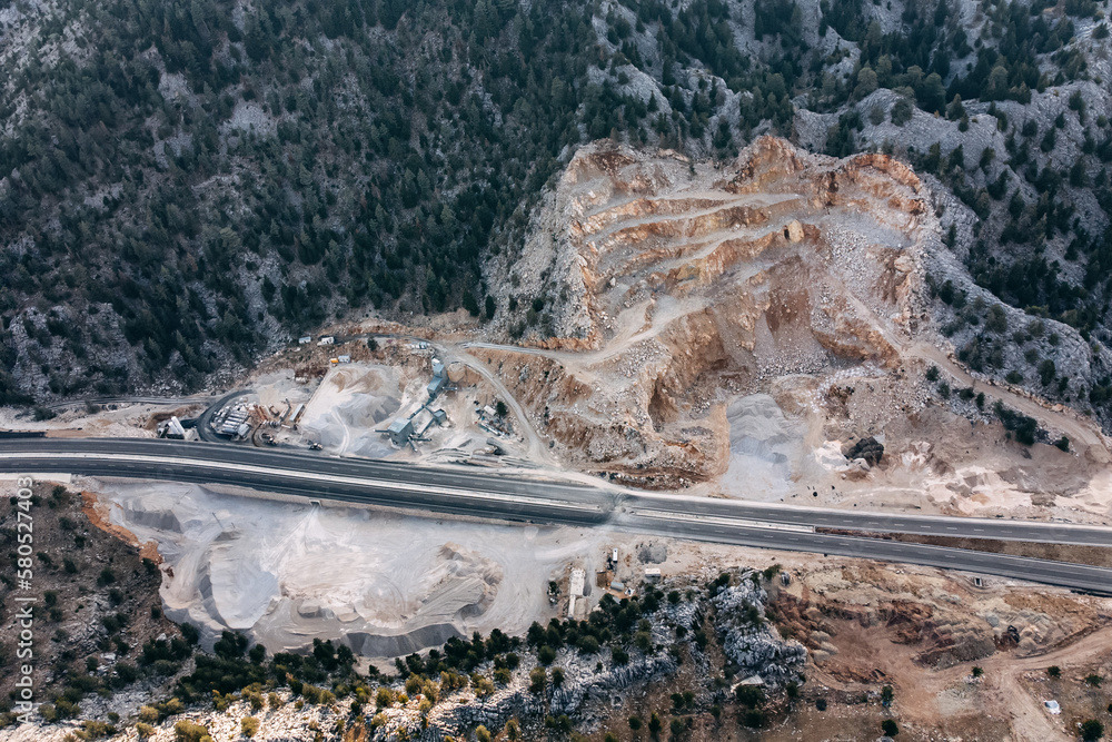 Aerial view of a crushed stone quarry for road construction in mountainous areas. Ecology issues concept