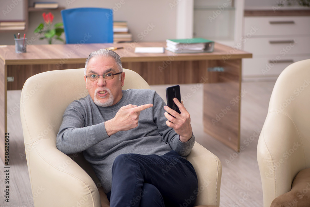 Old male employee working from home during pandemic