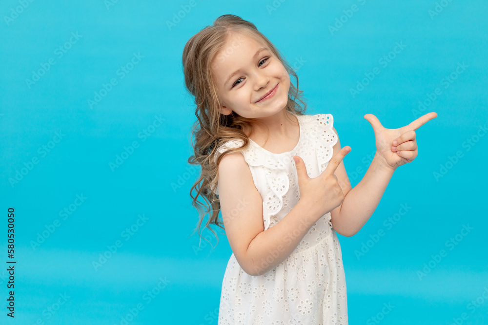 Happy cute little girl in a cotton white dress on a blue background in ...