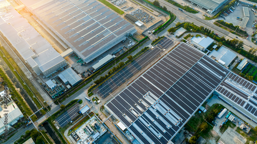 Top view Solar Panels on Warehouse Factory. Solar photo voltaic panels system power or Solar Cell on industrial building roof for producing green ecological electricity. Production of renewable energy