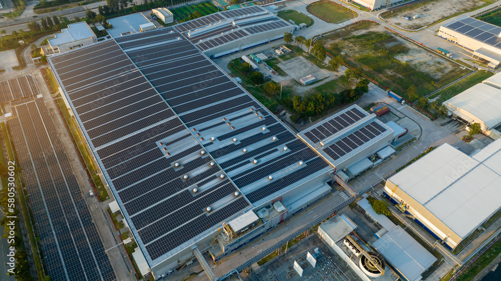Top view Solar Panels on Warehouse Factory. Solar photo voltaic panels system power or Solar Cell on industrial building roof for producing green ecological electricity. Production of renewable energy Top view Solar Panels on Warehouse Factory. Solar photo voltaic panels system power or Solar Cell on industrial building roof for producing green ecological electricity. Production of renewable energy