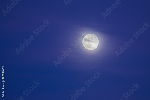moon with soft clouds on the sky during blue hour