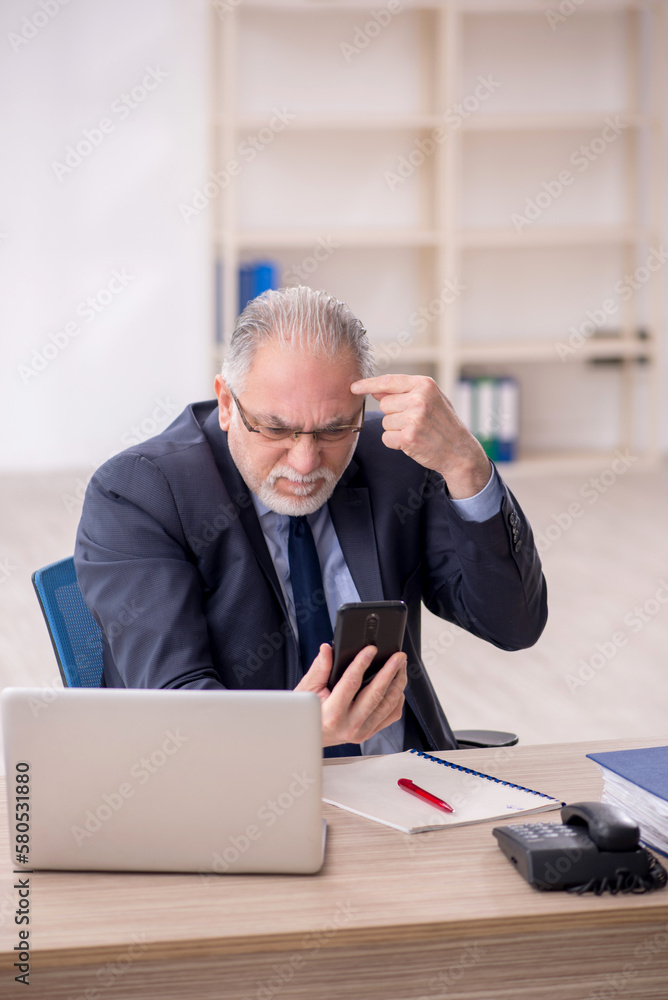 Old male employee working in the office Old male employee working in the office