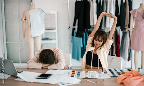 Two professional designers are exhausted, tired, fatigue, burned out, and sleepy at work because prolonged working hours makes them less responsible and productive. Poor balance between work and life