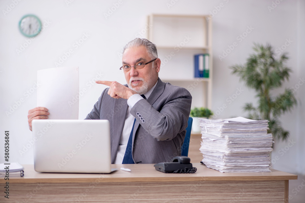 Old male employee working in the office Old male employee working in the office