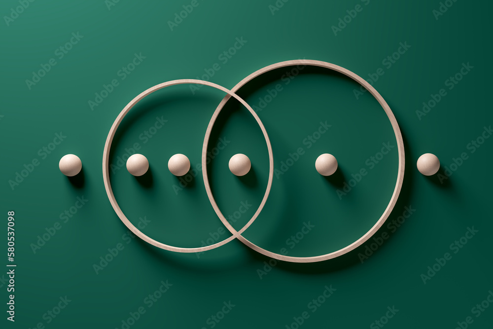 Crossing wooden rings with spheres in a row on green background. - obrazy, fototapety, plakaty 