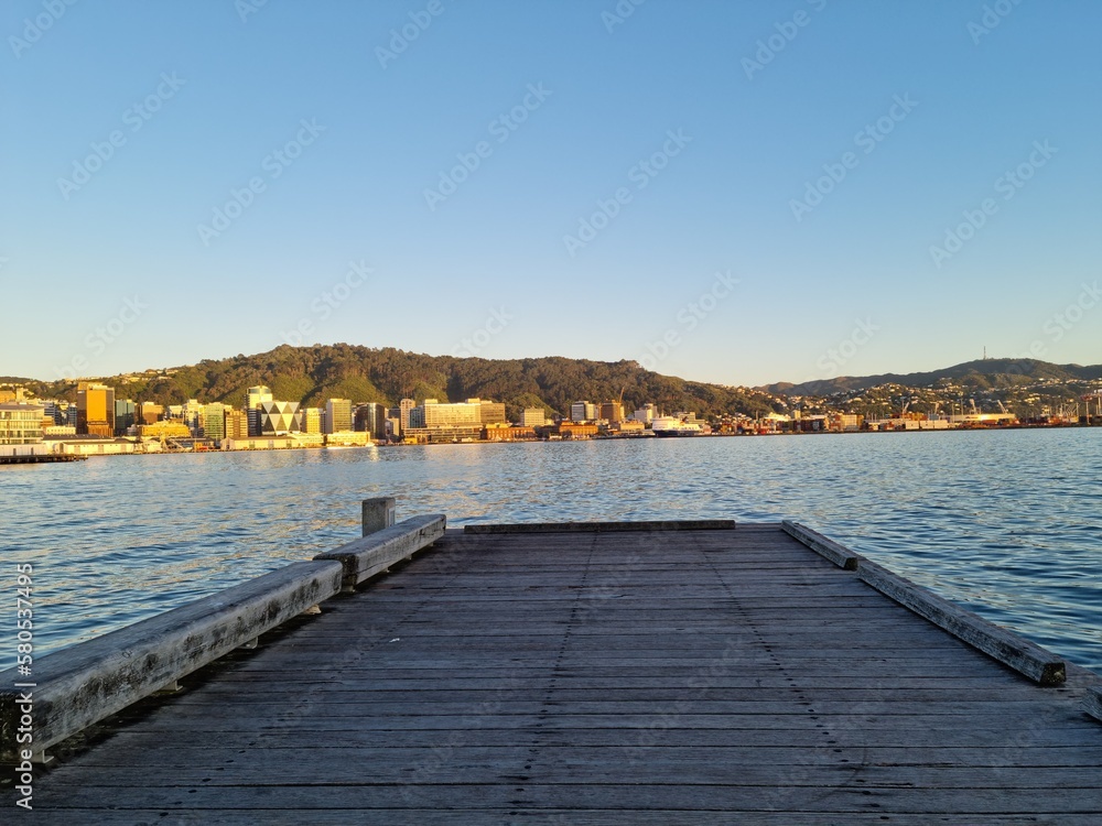 looking off the edge of the pier at the city in the morning