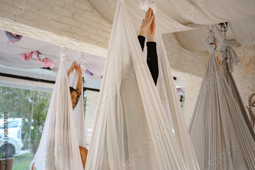 workshop of air yoga and stretching in yoga studio. women practices different inversion antigravity yoga with hammock. balance between mental and physical, one person effort and achievement concept © YURII Seleznov