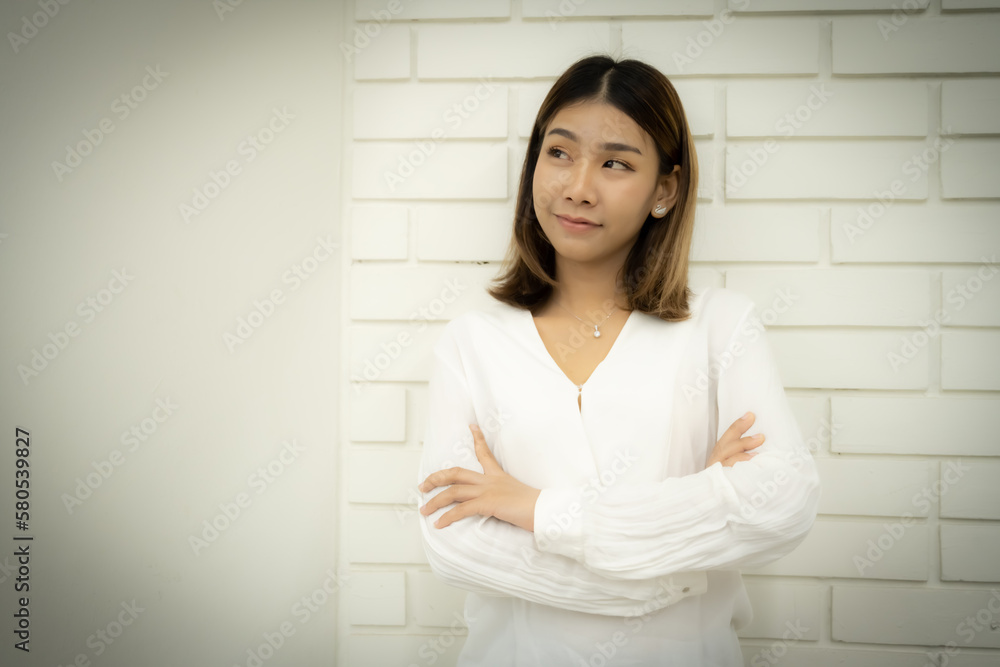 Portrait of a beautiful business woman is standing with arms crossed pretending to think in copy space with a doubtful expression. Portrait of a beautiful business woman is standing with arms crossed pretending to think in copy space with a doubtful expression.