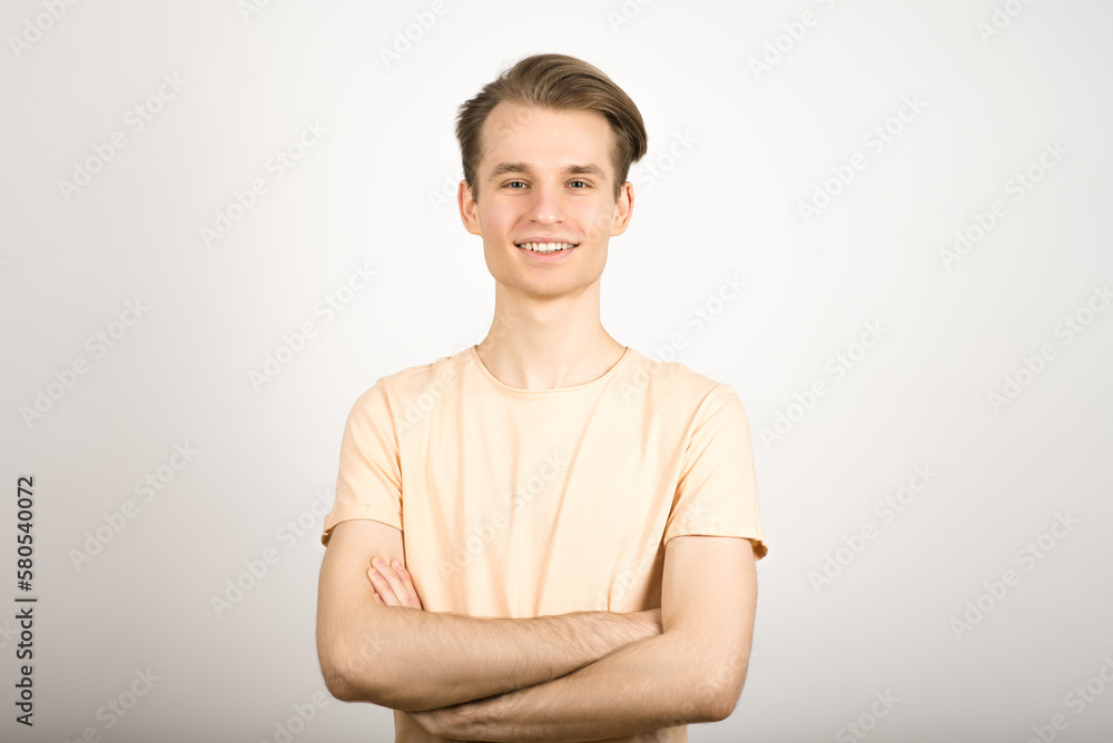 Portrait of a blond guy with crossed arms on a white background. Portrait of a blond guy with crossed arms on a white background.