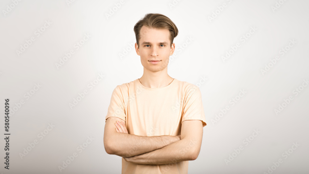 Portrait of a blond guy with crossed arms on a white background. Portrait of a blond guy with crossed arms on a white background.