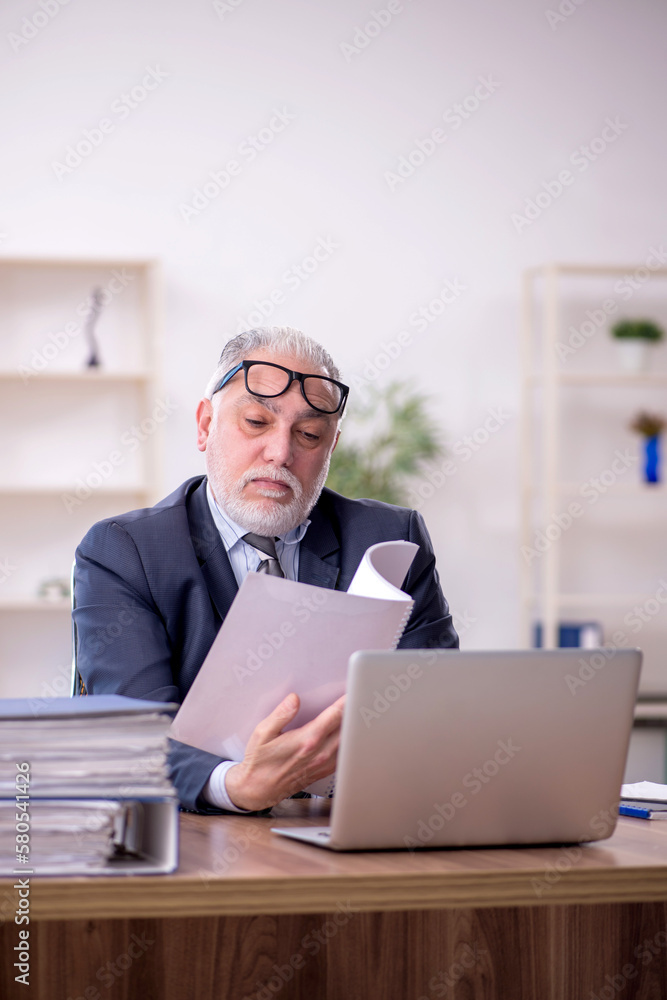 Old male employee and too much work at workplace Old male employee and too much work at workplace