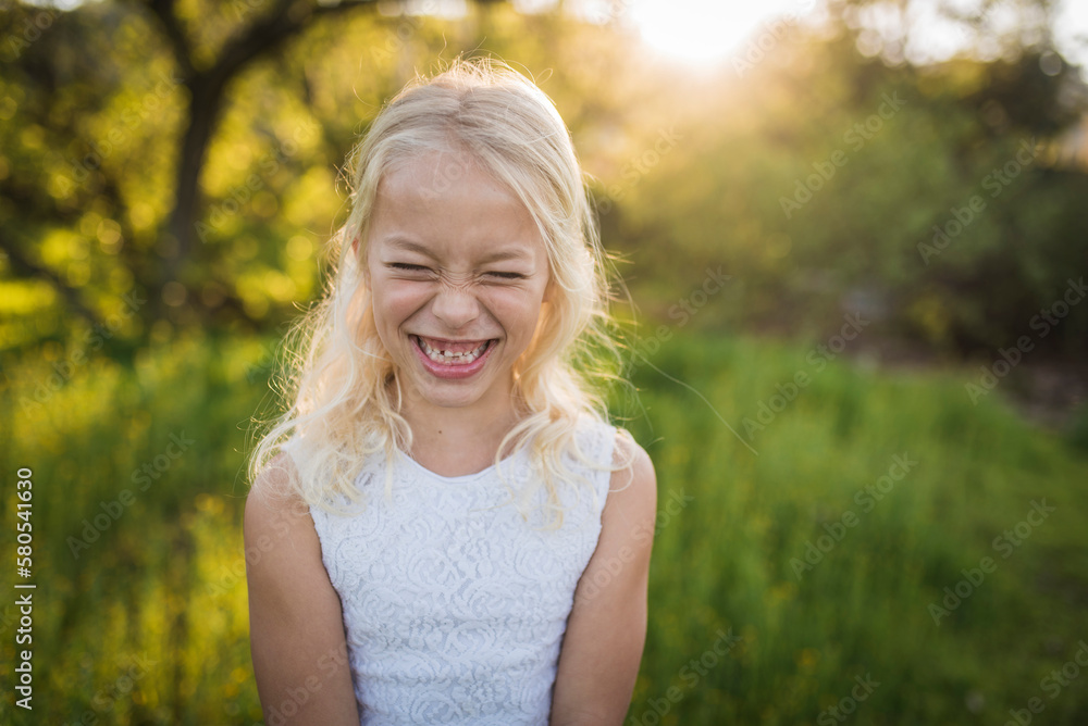 Cheerful girl standing on field in park Cheerful girl standing on field in park