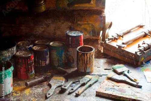 High angle view of paint cans with paintbrushes on wooden table photo