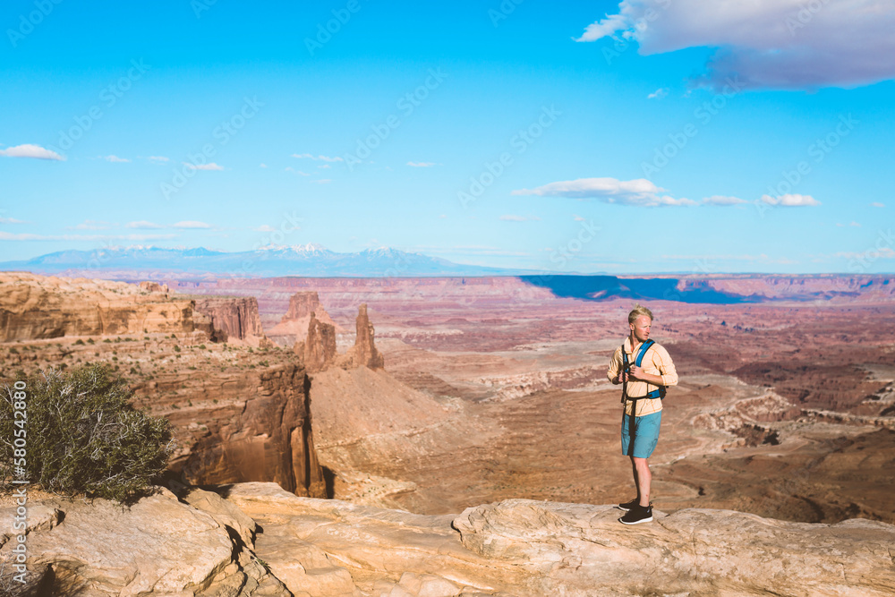 Full length of male hiker standing on mountain against blue sky Full length of male hiker standing on mountain against blue sky