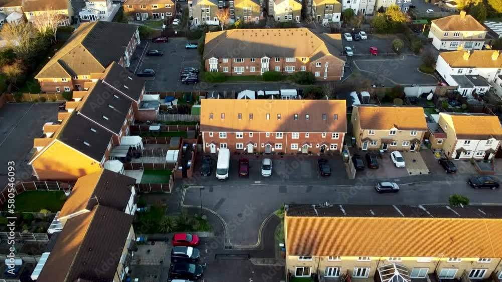 Cinematic aerial of birds flying and suburbs of London during golden hour sunset.