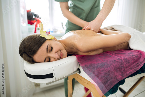 female masseur doing weight loss massage on woman's back