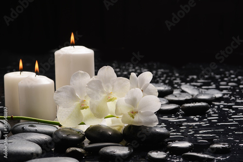 Spa still with white orchid  close up candle with black zen stones 