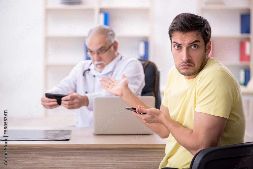 Young male patient visiting old male doctor Young male patient visiting old male doctor