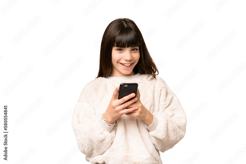 Little girl over isolated green chroma key background sending a message with the mobile Little girl over isolated green chroma key background sending a message with the mobile