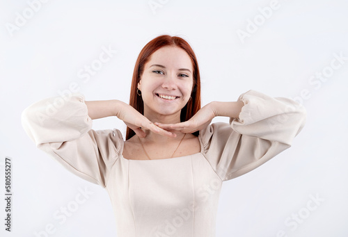 portrait of a young beautiful woman touching her face on white background, copy space