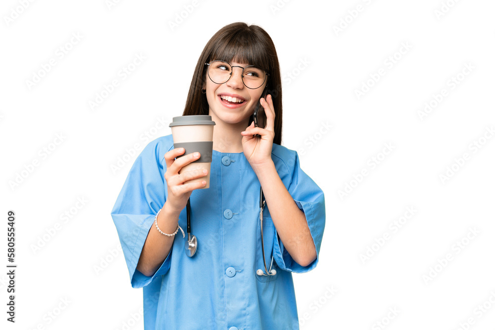 Little girl as a surgeon doctor over isolated chroma key background holding coffee to take away and a mobile Little girl as a surgeon doctor over isolated chroma key background holding coffee to take away and a mobile