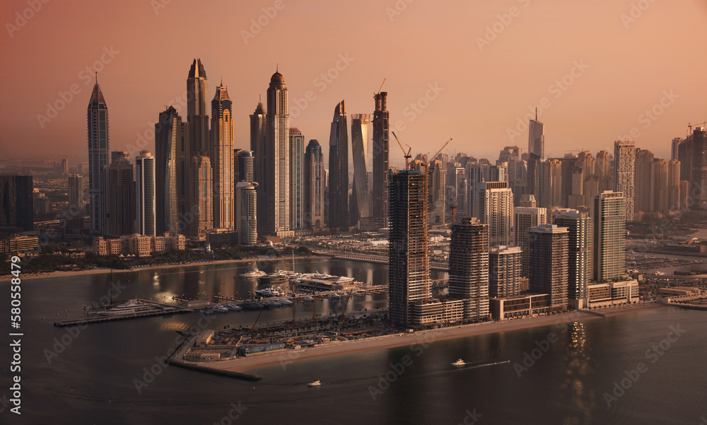 Dubai skyline on sunset, modern city with skyscrapers
