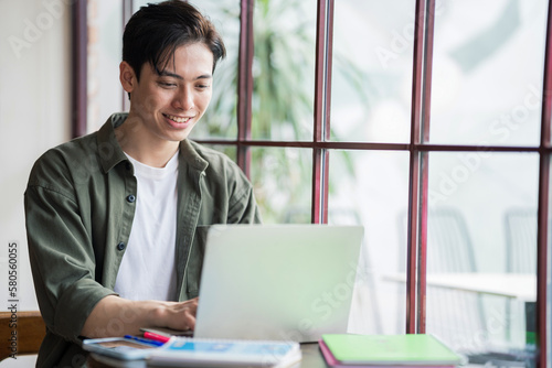 Young Asian businessman working at coffee shop