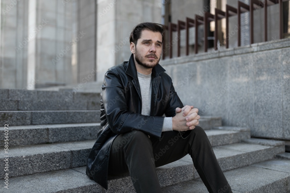 sad Man sits on the steps with sadness looks ahead sad Man sits on the steps with sadness looks ahead