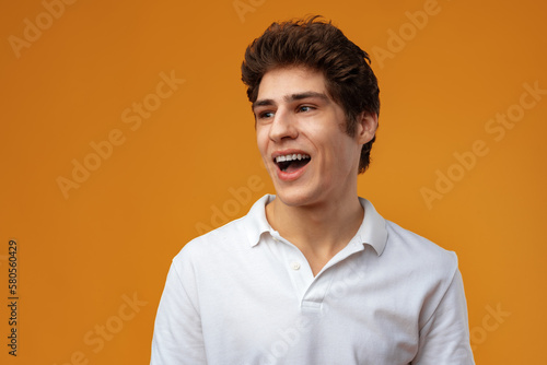 Portrait of a happy young casual man standing over yellow background © fotofabrika