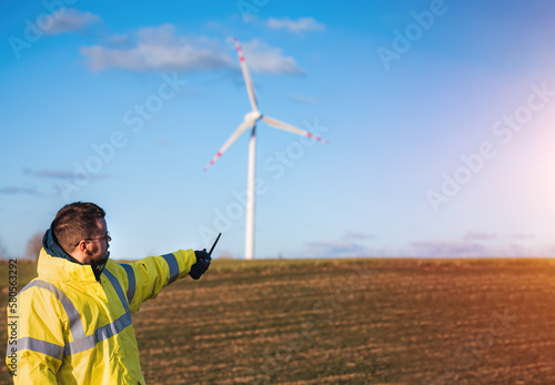 person standing next to wind turbine