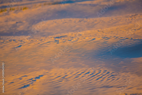 Sunset sand dunes with shadows on the beach