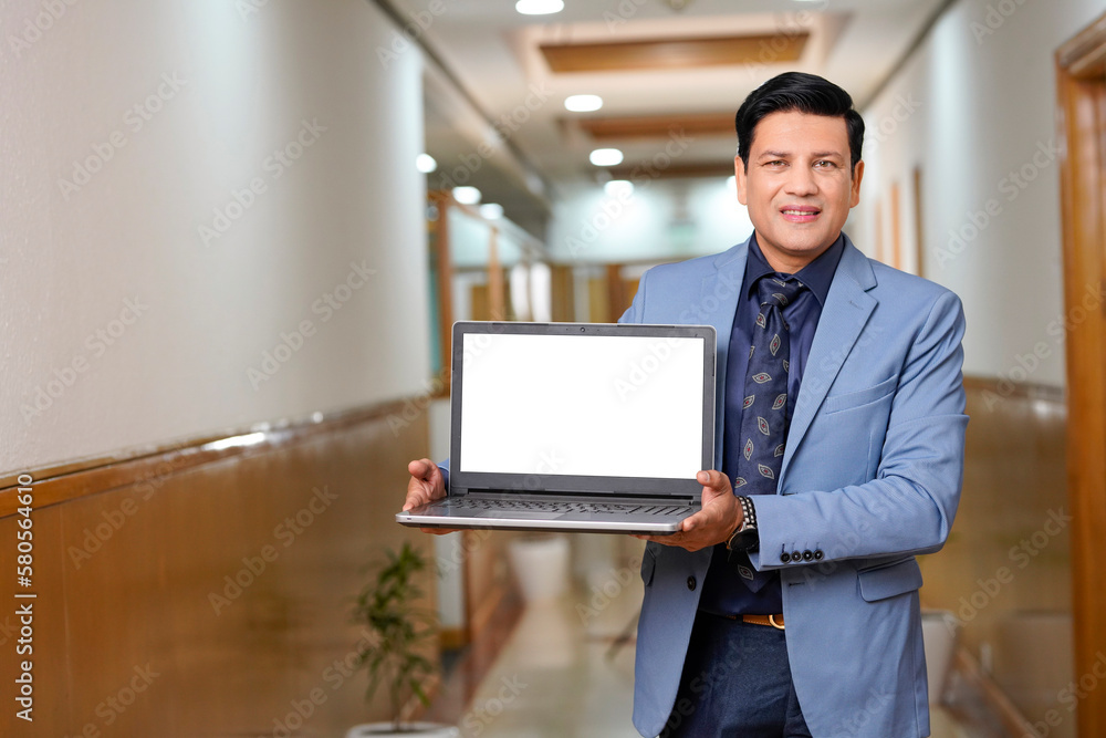 Indian businessman showing blank laptop screen Indian businessman showing blank laptop screen