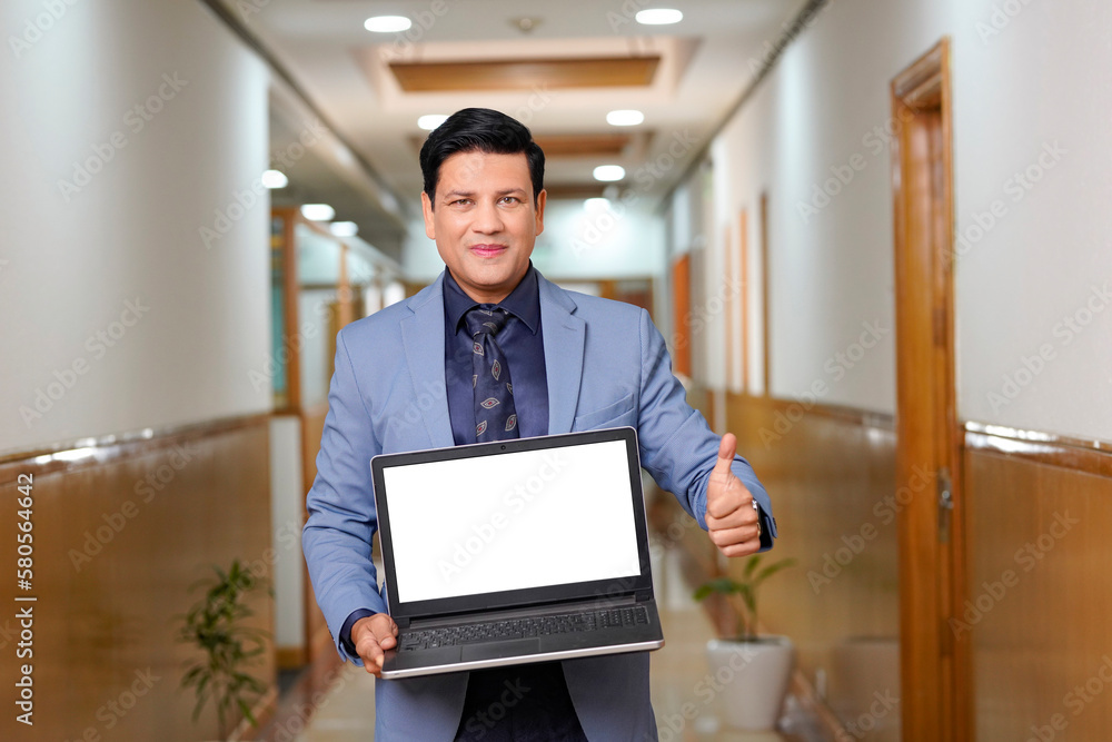 Indian businessman showing blank laptop screen Indian businessman showing blank laptop screen