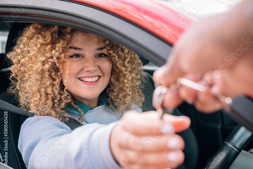 Happy woman giving car keys to personal valet photo