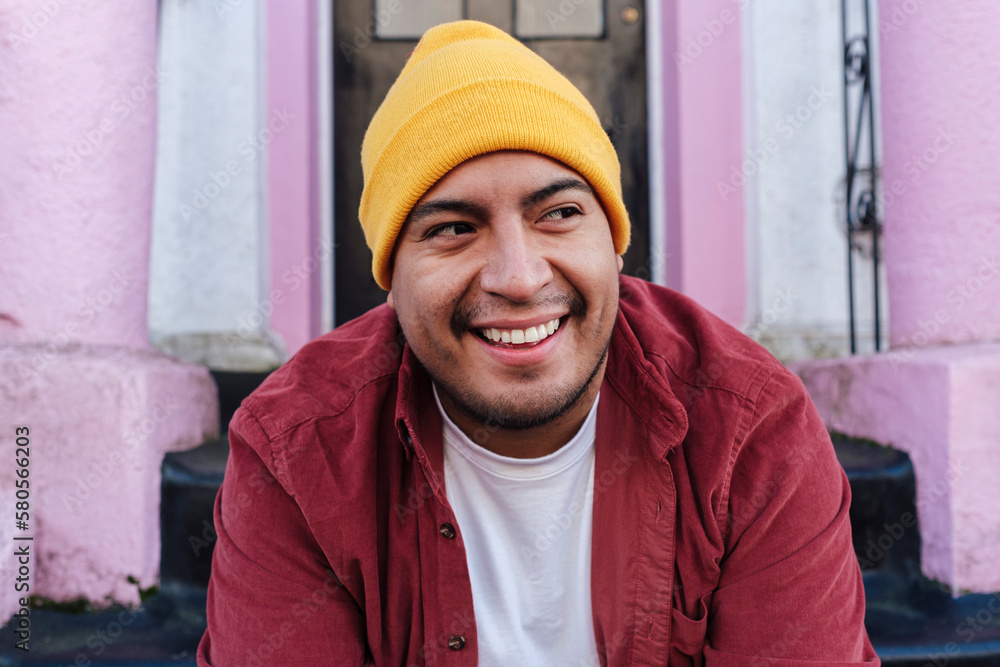 Smiling man wearing knit hat in front of door Smiling man wearing knit hat in front of door