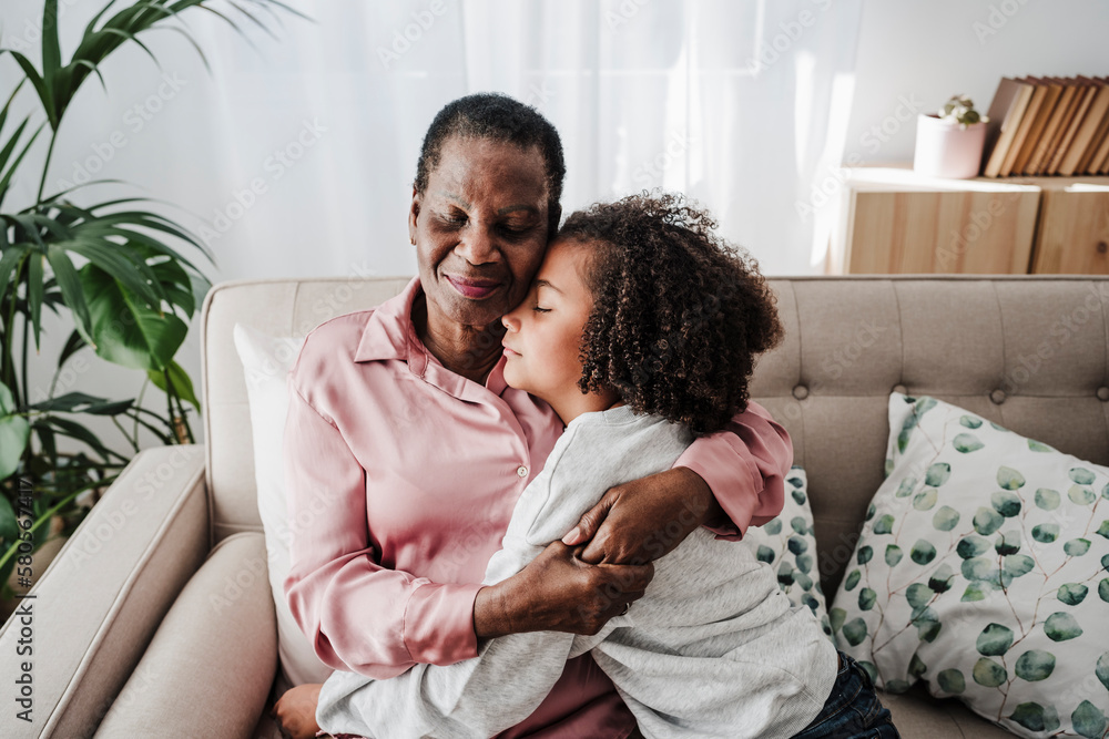 Girl resting with grandmother sitting on sofa at home Girl resting with grandmother sitting on sofa at home