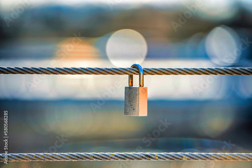 Padlock hanging on steel cable photo